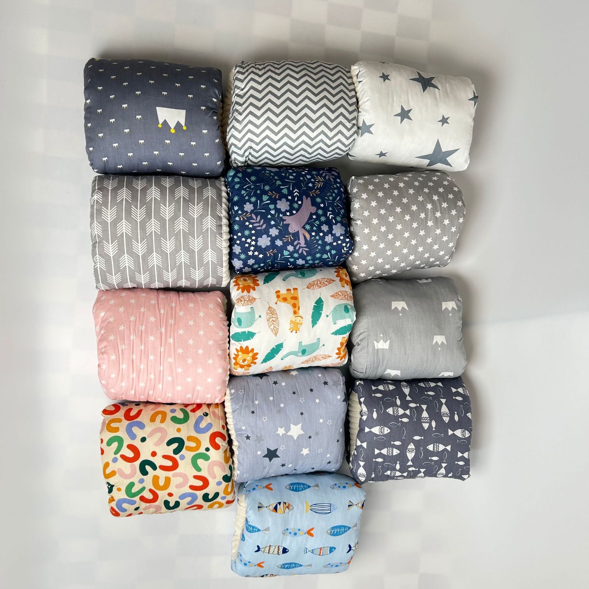 Assorted baby blankets with playful patterns and colors, ideal for comfort and play.
