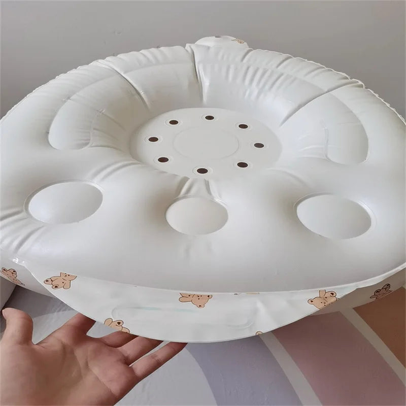 White inflatable baby bath cushion with cute bear print, ideal for infant comfort and safety.