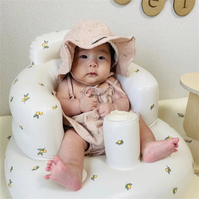 Baby in pink outfit and sun hat seated in floral baby chair, Kid Zone educational toys