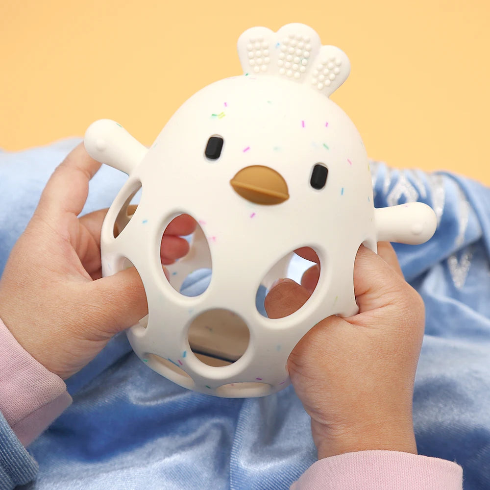 Baby holding a soft chicken-shaped sensory educational toy on a blue blanket, Kid Zone