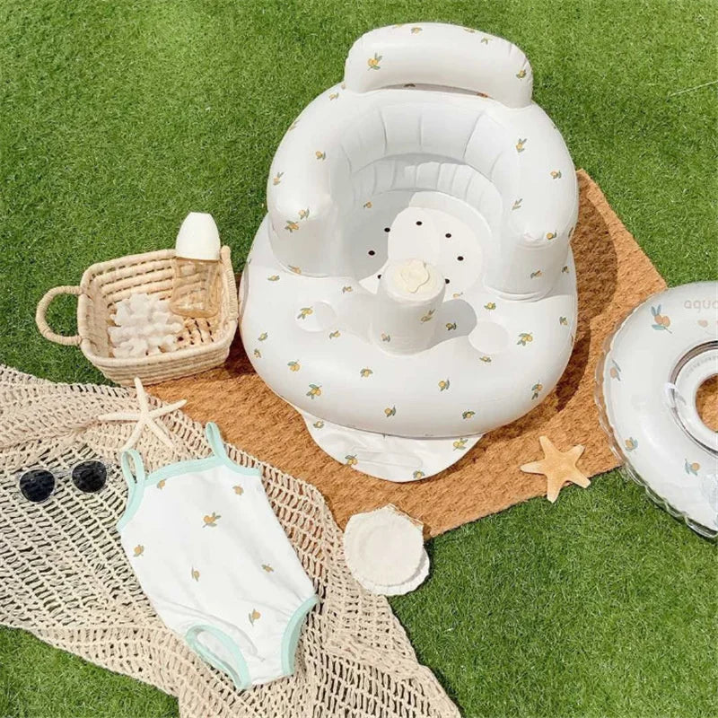 Baby swim seat, swimsuit, and accessories on grass, perfect for summer play and comfort.