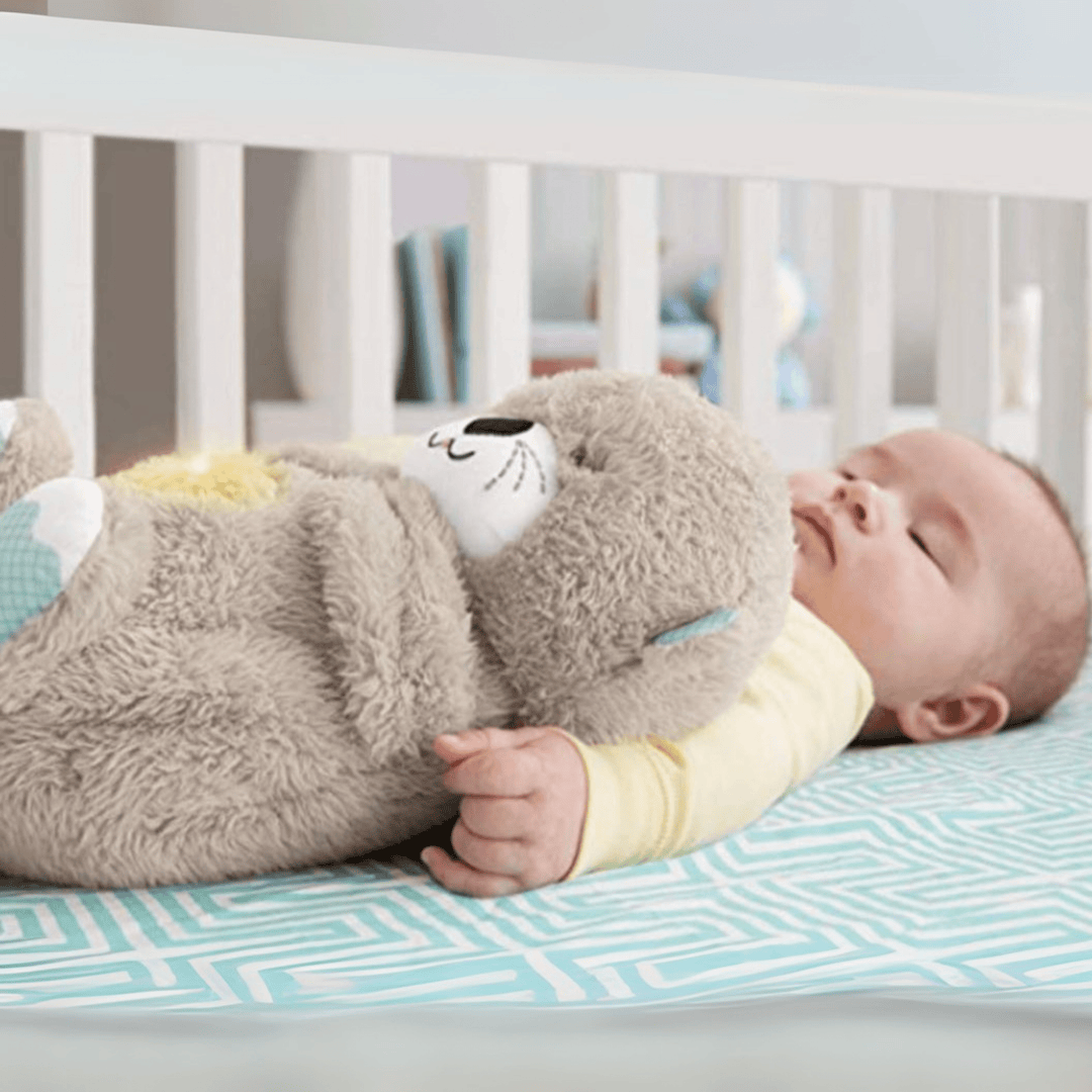 Baby sleeping in crib hugging plush otter calming toy, Kid Zone educational toy